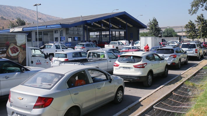 Fila de vehículos esperando ingresar a una planta de revisión técnica